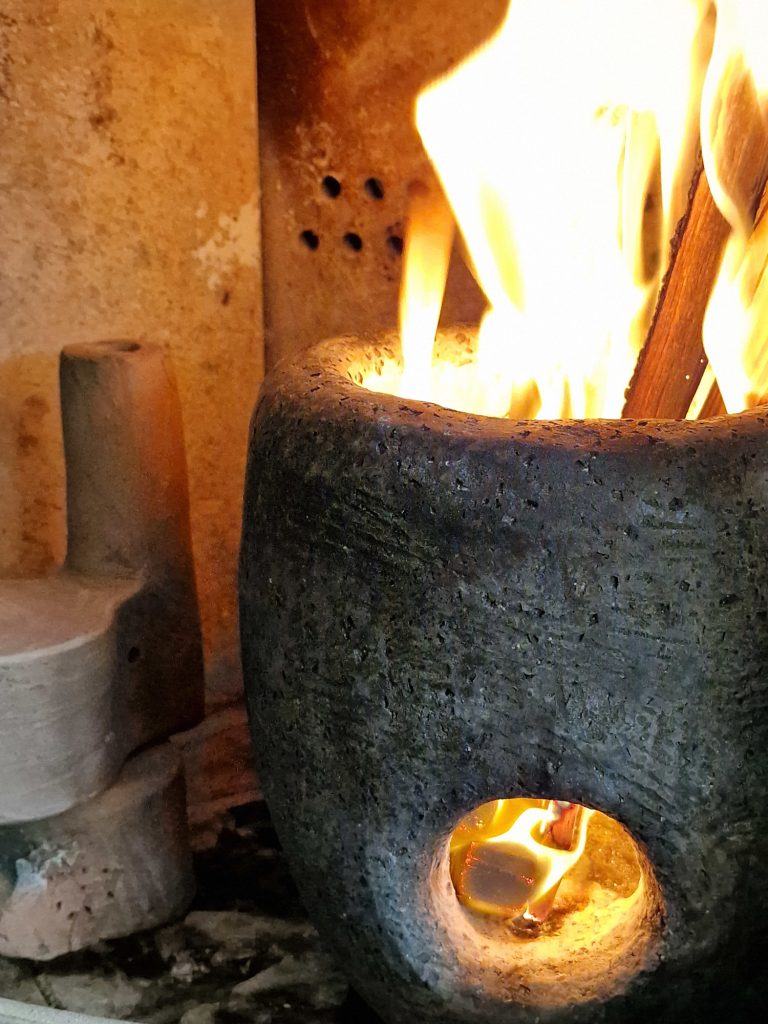 Bisque fire ceramic in an wood stove, pre heat the ceramics with a fire-pot, long flames