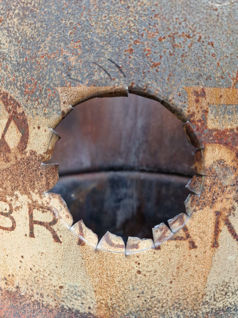 Cut hole in the oil drum with an handheld metal shear